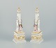 L'Art 
præsenterer: 
Royal 
Copenhagen 
Flora Danica, 
et par 
obelisker til 
borddekoration. 

Puttier 
omkranset af 
...
