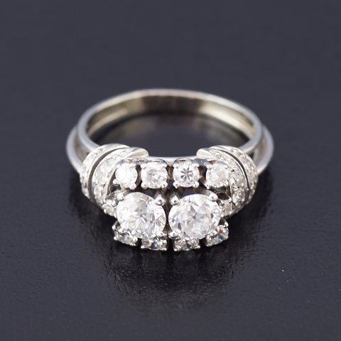 A ring set with 2 big and 8 smaller brillants and with 9 small diamonds mounted 
in 18k white gold