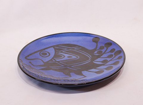 Stort rundt keramik fad med mørkeblå glasur og motiv af fisk, af Pottemagerstuen 
på Graabrødretorv 1.
5000m2 udstilling.