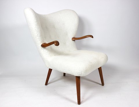 Armchair upholstered with sheep skin and with arms of dark wood of danish design 
from the 1930s.
5000m2 showroom.