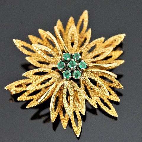A brooch set with emeralds, mounted in 14k gold