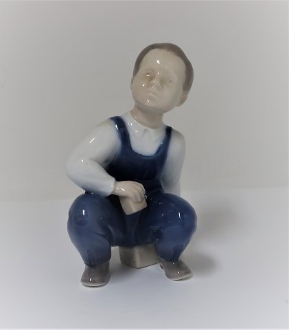 Bing & Grøndahl. Porcelænsfigur. Siddende dreng. Model 2402. Højde 12 cm. (1 
sortering)