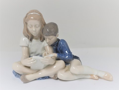Royal Copenhagen. Porcelain figure. Reading boy and girl. Model 4670. Height 
13.5 cm. (1 quality)