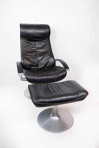 Lænestol med skammel polstret i sort læder og stel af metal, af Dansk design fra 
1970erne.
5000m2 udstilling.