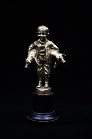 Old bronze figure of the pig boy holding 2 small pigs under the arm. The figure 
stands on a small pedestal in wood. Height: 14,5cm.