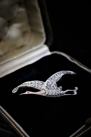 Old brooch in silver in the shape of a bird 
with lots of small shiny magazines. 5x2,5cm.