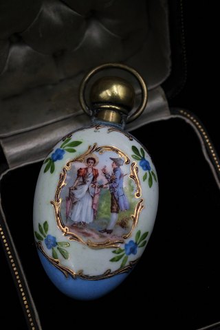 1800 century perfume bottle in porcelain with hand-painted motif , gold 
decoration and brass lid. H:8,5cm. W:4cm.