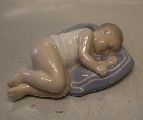4496 Kgl. Baby sover på pude  4 x 15 x 10 cm Holger Christensen Kongelig Dansk 
Porcelænsfigur