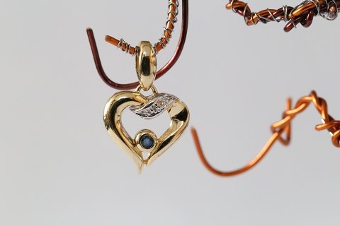 Hjerteformet vedhæng i 14 karat guld, med  brillanter og en blå safir i midten. 
Meget elegant. 
Stemplet 585 SIS