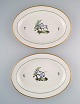 To store ovale Royal Copenhagen serveringsfade i håndmalet porcelæn med 
fuglemotiver og gulddekoration. Tidligt 1900-tallet. 
