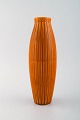 Bo fajans, Sverige. Vase i glaseret keramik med riflet korpus. Smuk glasur i 
mørke orange nuancer. 1960/70