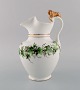 Antique Bing & Grøndahl chocolate jug in porcelain modeled with a lion on the 
handle. Hand-painted flowers and gold decoration. 1870s.
