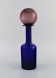 Otto Brauer for Holmegaard. Vase/flaske i blåt mundblæst kunstglas med lilla 
kugle. 1960