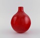 Scandinavian glass artist. Unique vase in red mouth-blown art glass with inlaid 
bubbles. Late 20th century.
