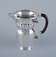 Georg Jensen, large Art Nouveau pitcher in sterling silver. Early and rare 
model. Hammered finish. Ebony handle.