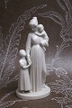 Royal Copenhagen hvid porcelænsfigur af "Moderkærlighed" mor med sine 2 børn. 
Design Herman W. Bissen...