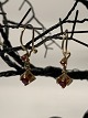 Gold earrings in 14 carat gold, inlaid with red rubies.
Stamped: 585.