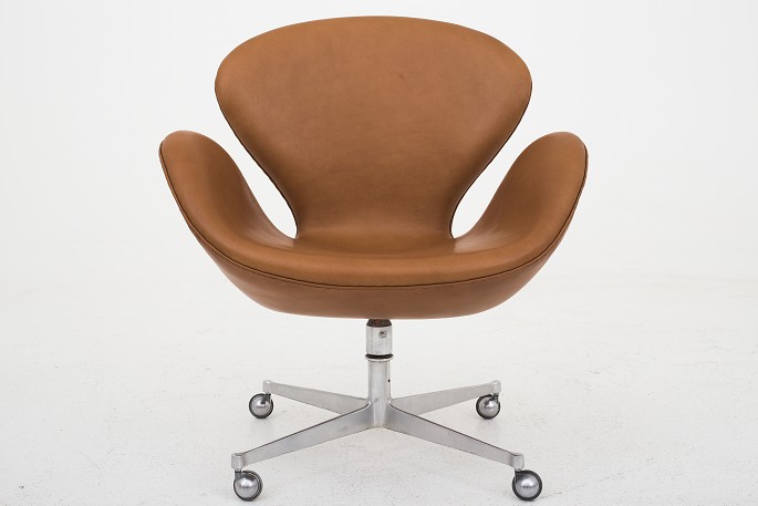 Arne Jacobsen / Fritz Hansen
AJ 3324 - Nybetrukket "Svanen" i KLASSIK Cognac-læder med hjul og vip. Gammel 
fod.
Leveringstid: 6-8 uger
Vi tilbyder polstring af Svanen med stof eller læder efter eget valg. Kontakt 
os venligst for mere information.
