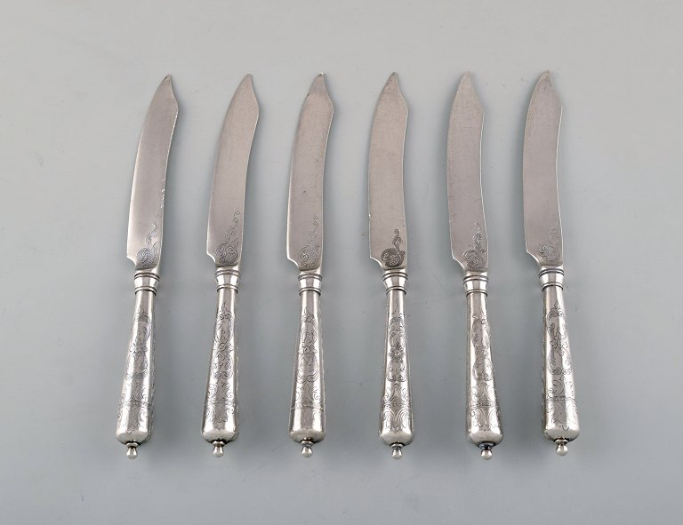 Dansk sølvsmed. Seks antikke knive i tretårnet sølv med blomster ciseleringer. 
Dateret 1918.

