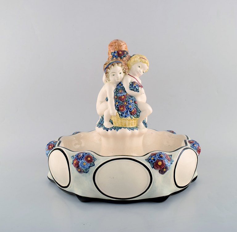 Wilhelm Süs (1861-1933) for Karlsruher Majolika. Large art nouveau compote in 
hand painted faience / majolica with playful children and flower decorations. 
Ca. 1910.
