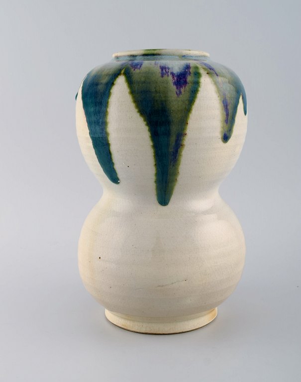European studio ceramist. Large unique vase in glazed ceramics. Beautiful green 
blue glaze on a cream background. 1980