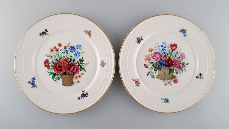 KPM, Berlin. To antikke tallerkener i porcelæn med håndmalede blomsterkurve og 
guldkant. Tidligt 1900-tallet.
