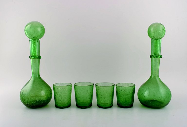 Biot, Frankrig. To vinkarafler og fire glas i grønt mundblæst kunstglas med 
indlagte bobler. Midt 1900-tallet.
