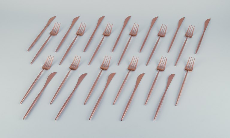 Et tolvpersoners modernistisk middagsbestik i messing.
Bestående af tolv middagsknive og tolv middagsgafler.
